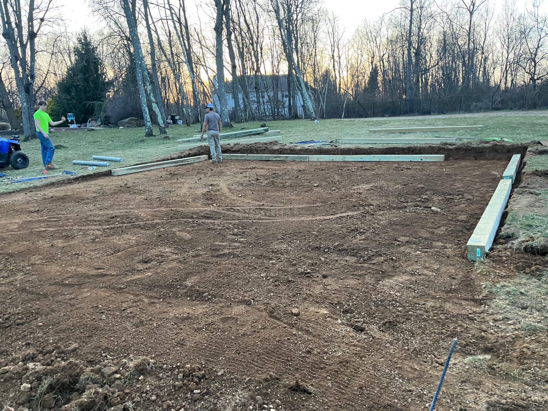 Before photo of a large excavated yard area prepared for playground installation.